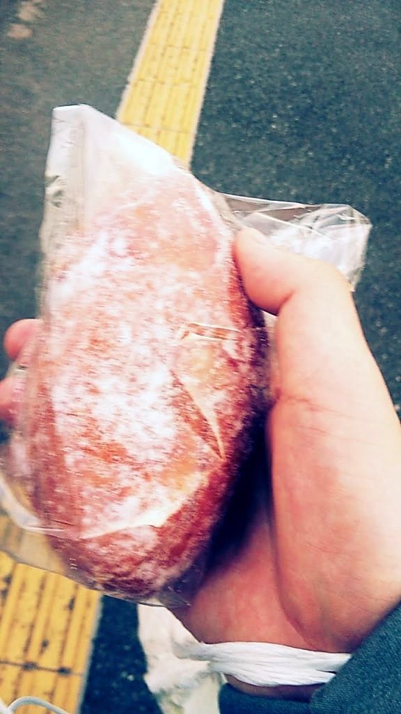 歩きながら手に持ったクリームドーナツ。