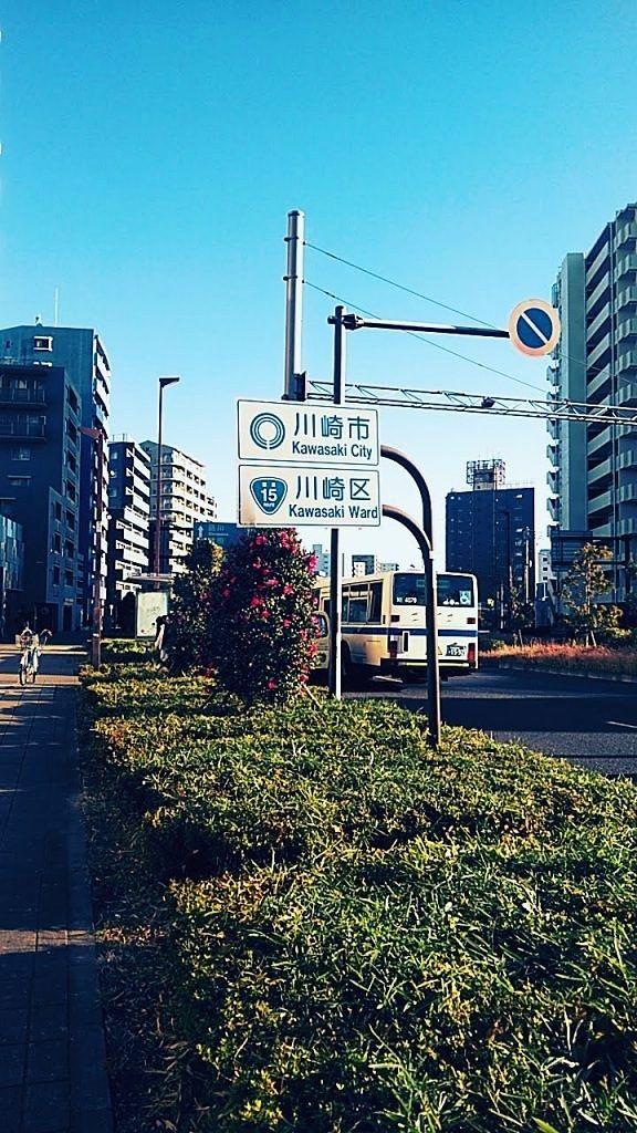朝の空の下の「川崎市 川崎区」の標識。
