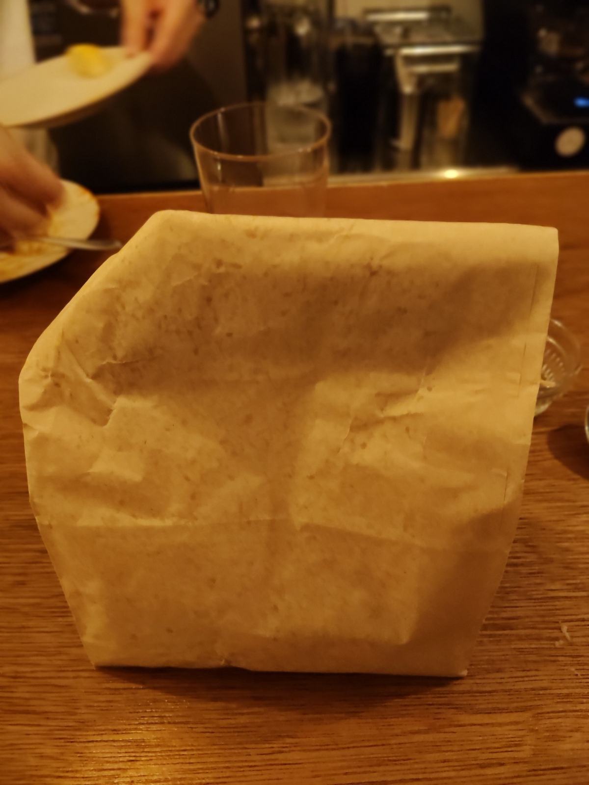 トリュフポップコーンの茶色い紙袋。カウンターの上で上を折って閉じてあり、このまま持ち帰れる。