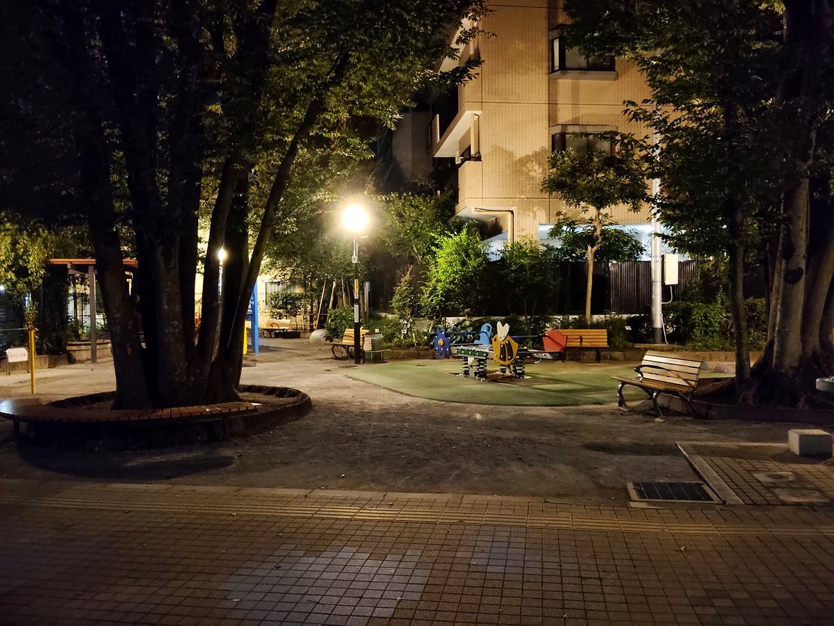 深夜の誰もいない公園。滑り台やベンチがそのままの形で置かれている。