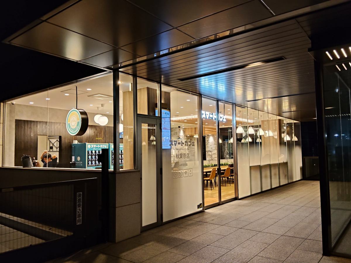 深夜3時45分のスマートカフェ秋葉原。暗い街の中で、ガラス張りの店内だけが明るい。