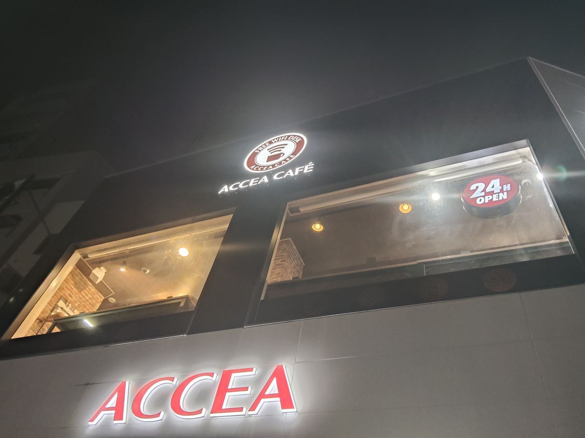 アクセアカフェ神保町店の入口。赤いネオンと「24」の表示