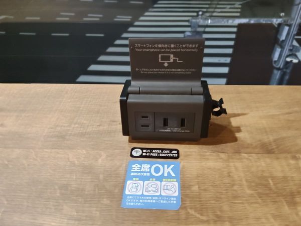アクセアカフェの机の上の電源ユニット。「全席OK」の表示。