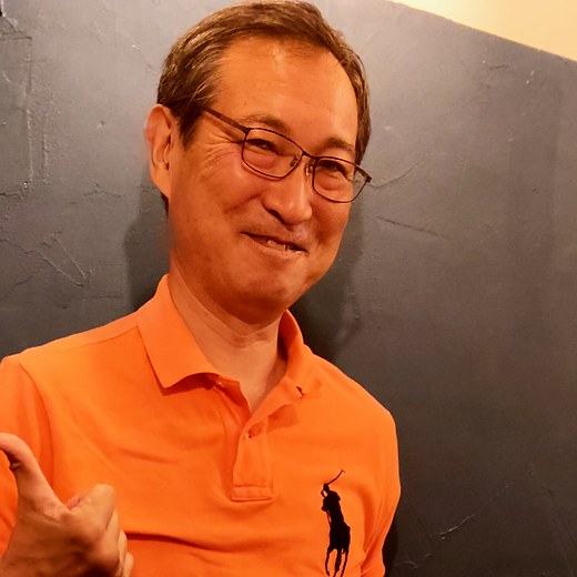 オレンジのポロシャツで親指を立てる奥山さん。