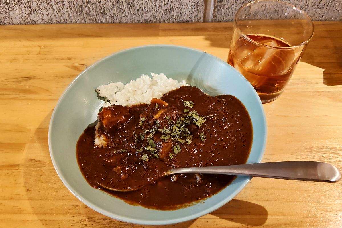 水色の器に盛られたポルトカレー。白いごはんとスプーン、奥に氷の入ったグラス。