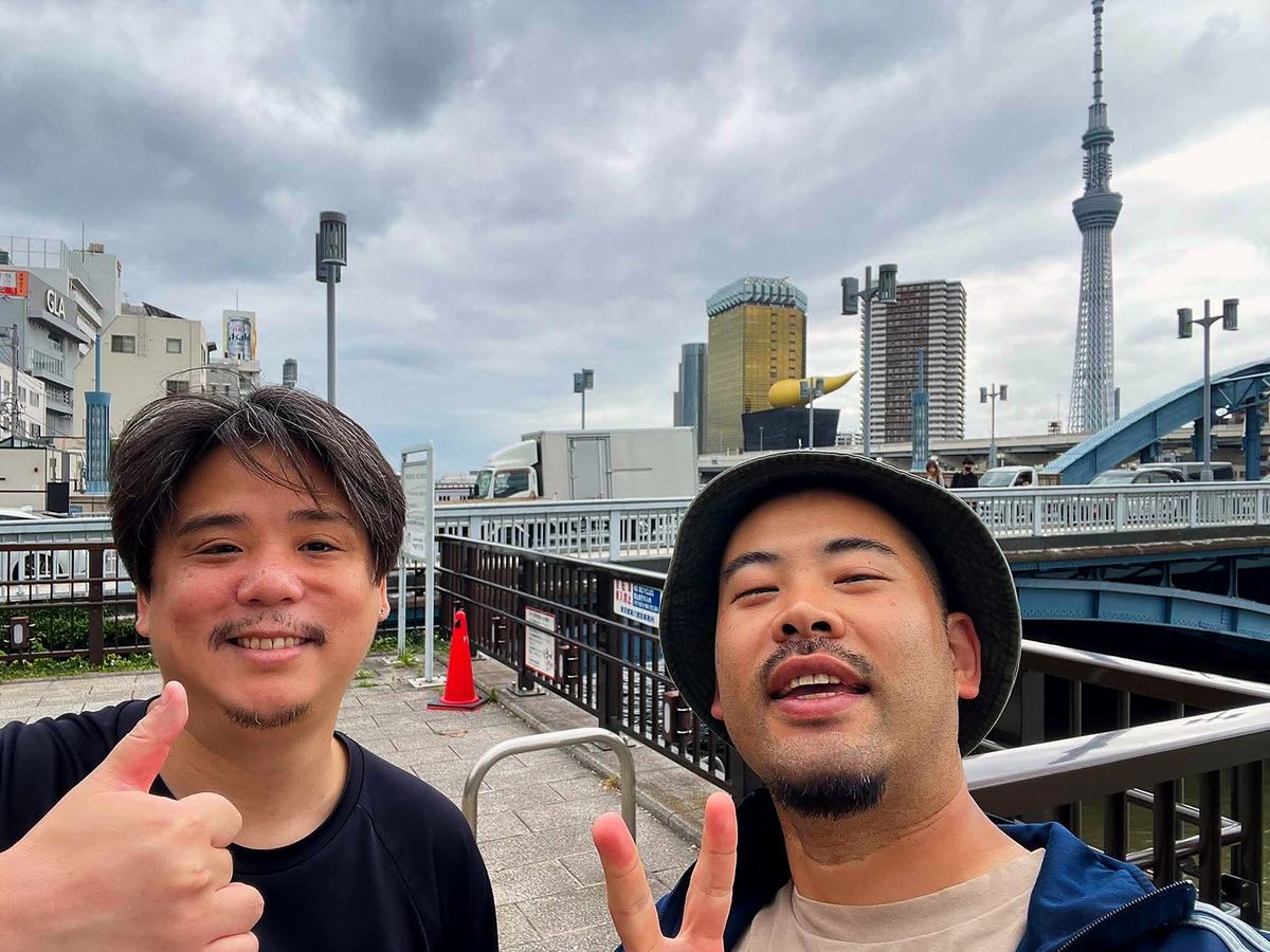 駒形橋のたもとで撮ったふたりの自撮り。奥にスカイツリーとアサヒビール本社。