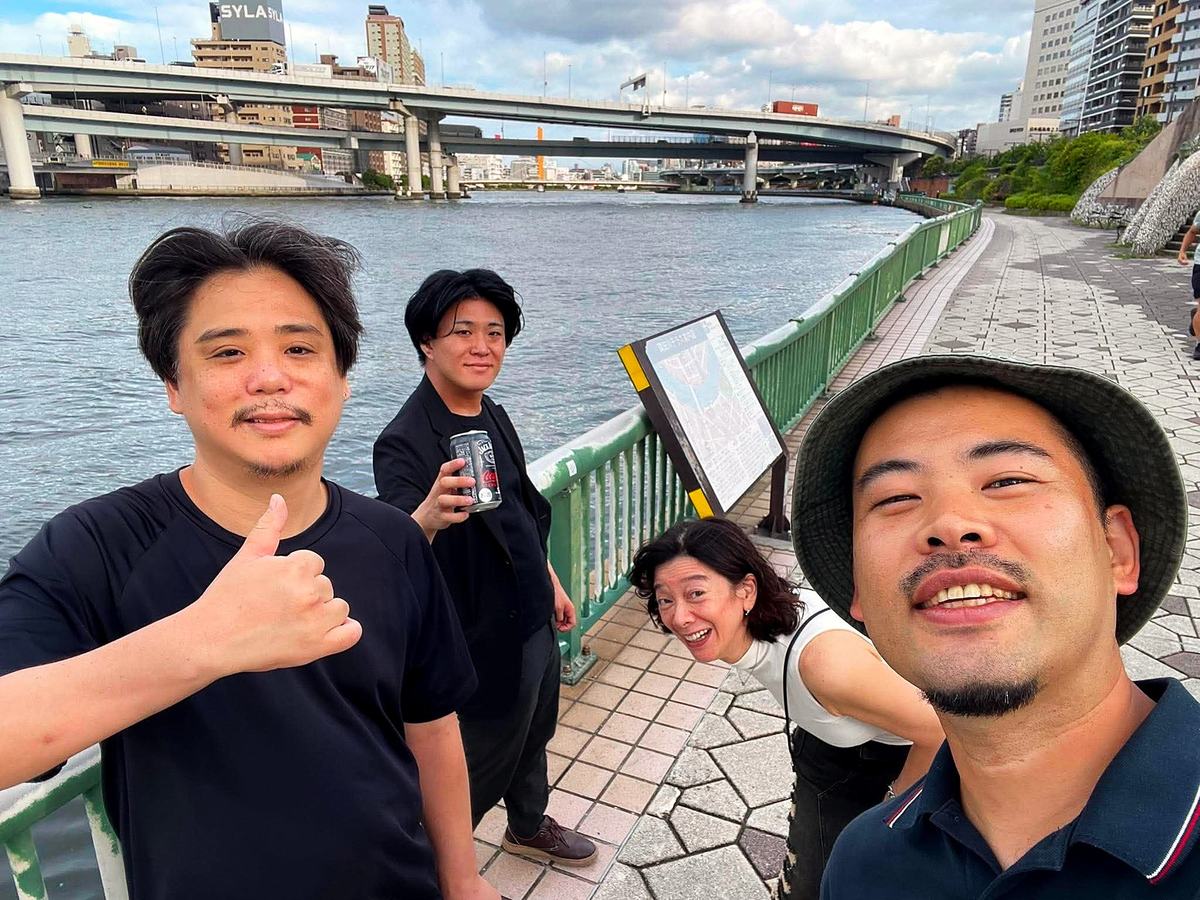 隅田川沿いの遊歩道で撮った四人の自撮り。首都高の高架と川。