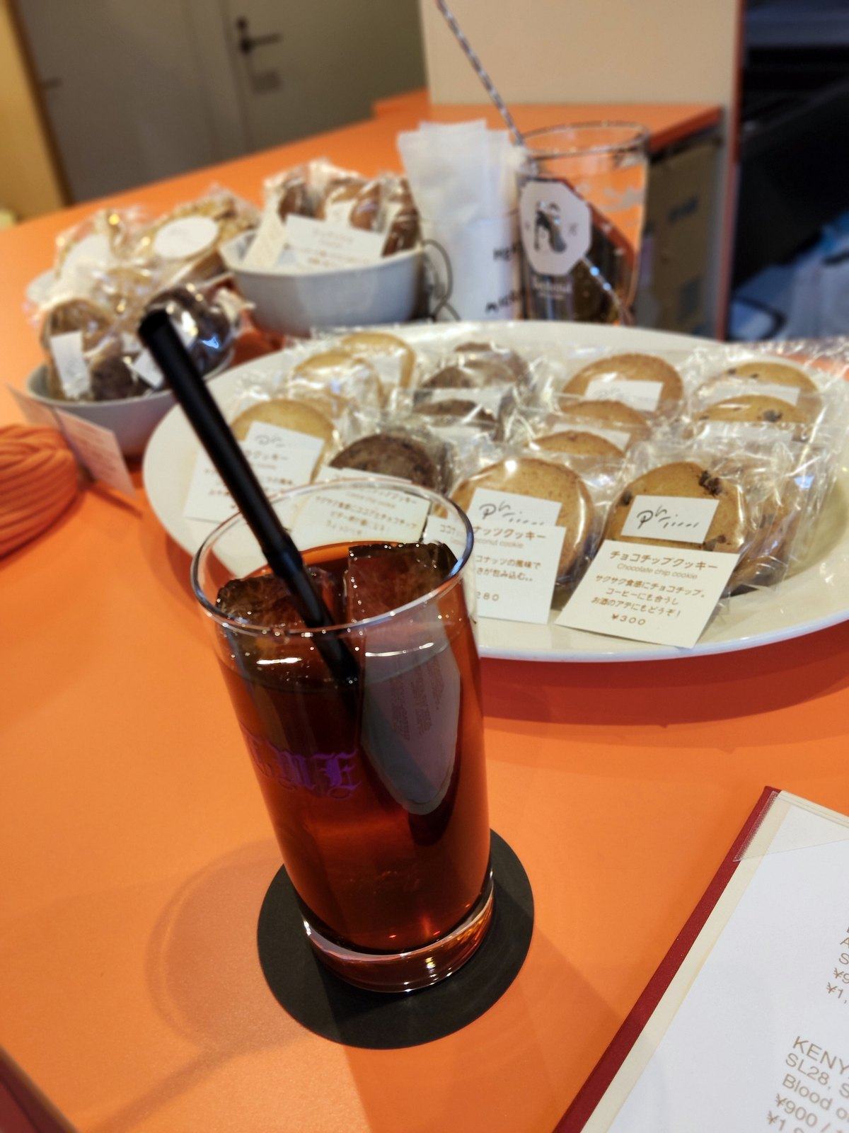 コースターの上のコールドブリュー。奥にクッキーの山。