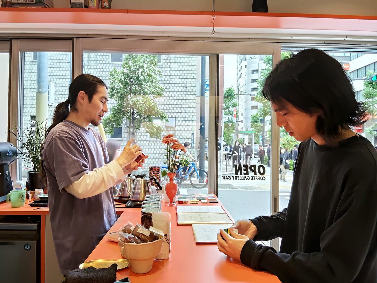ルービックキューブを挟んで向かい合うテツさんとマシューさん。