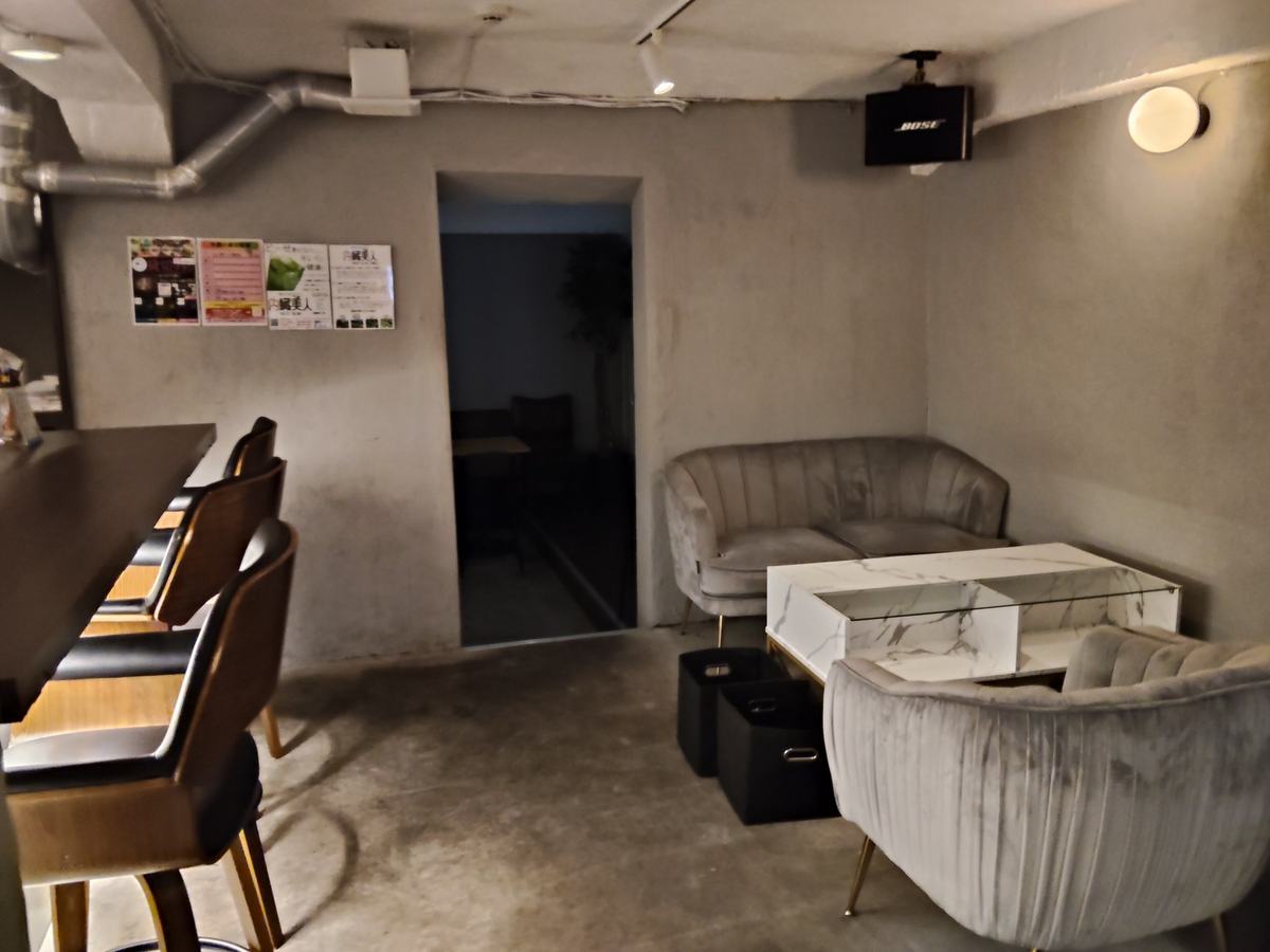 店の手前側。バーカウンターの近くに置かれたソファ席と、落とした照明。