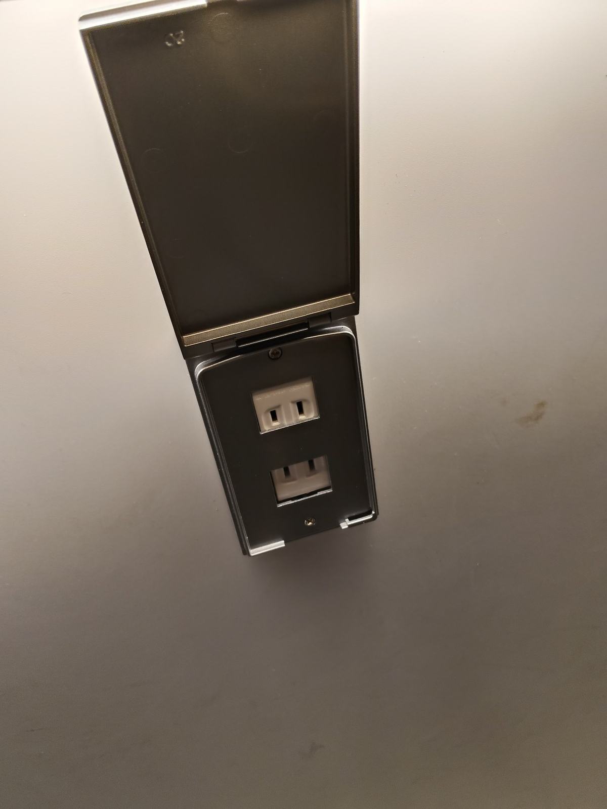 カウンター席の下に取り付けられた電源コンセント。