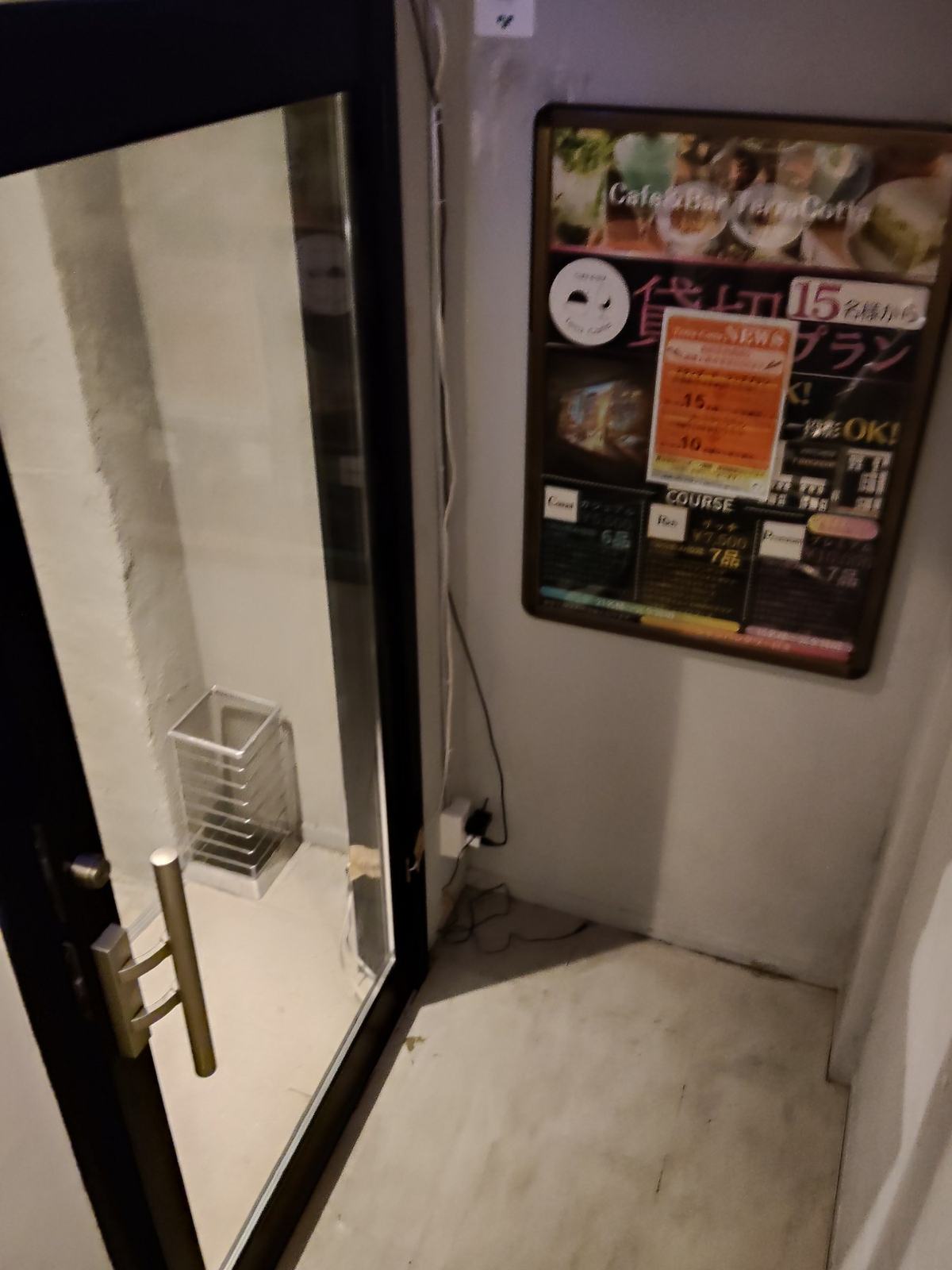 地下へ降りる階段。明るい照明に照らされたコンクリートの段と、白い壁。