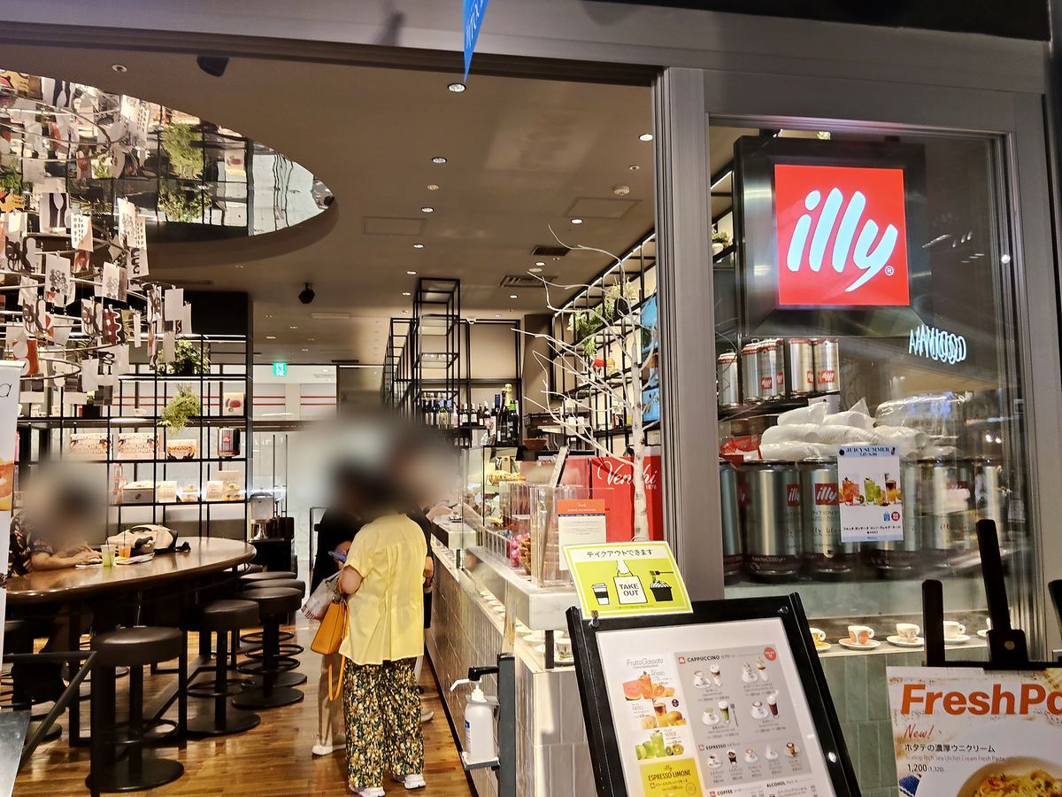 illy IL BAR の店先。赤いロゴの下にカウンターと丸テーブルが見える。