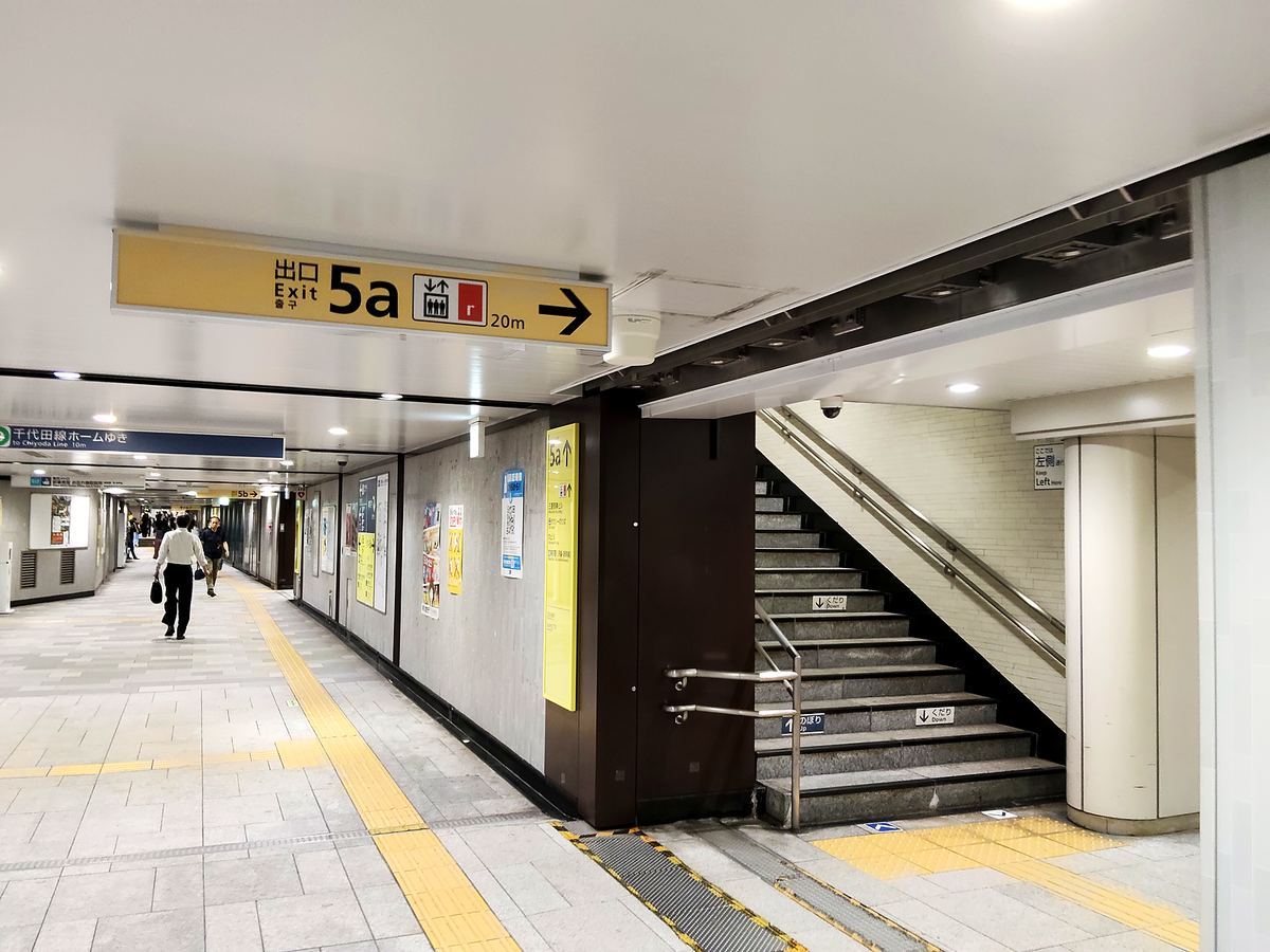 出口5aの黄色いサイン。右手に上りの階段が見える。